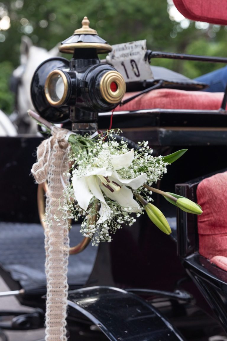 Fotografía de bodas en Córdoba Ramo de flores blancas decorando un carruaje tirado por caballos. reportaje de bodas en Córdoba
